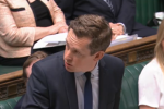 Tom participating in Home Office Questions in his role as Minister of State for Legal Migration and the Border in the House. He is turned towards a colleague, answering their question.