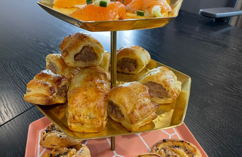Selection of savoury pastries on a tiered stand, such as sausage rolls