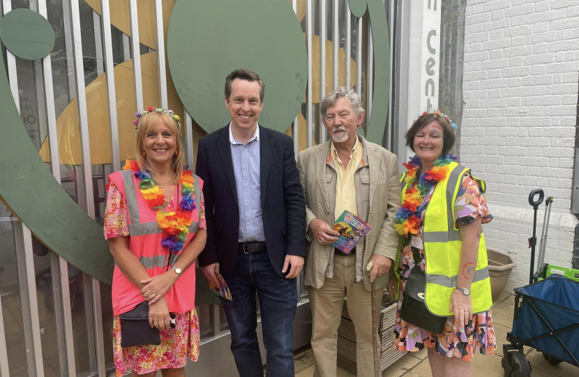 Tom stood next to senior members of staff from Pen Green. All four people in the photo are smiling and looking at the camera outside the front of the Pen Green Centre.