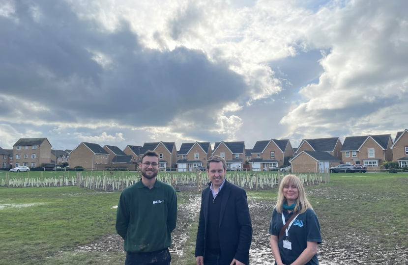 Tom Pursglove MP and two representatives from RAIN in front of the 'tiny forest' in Oakley Vale.