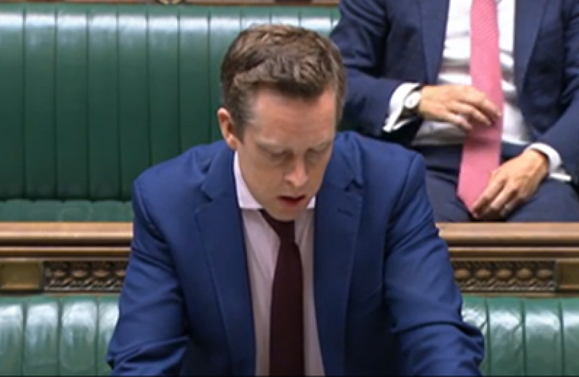 Tom stood in the House of Commons, answering a question. 