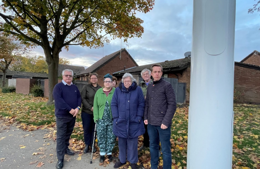 Tom Pursglove MP with a group of residents on Welland Vale Road in Corby, gathered next to the new 5G mast.