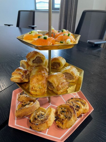 Selection of savoury pastries on a tiered stand, such as sausage rolls