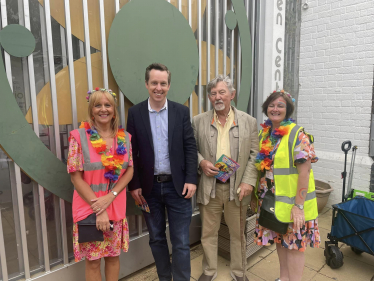 Tom stood next to senior members of staff from Pen Green. All four people in the photo are smiling and looking at the camera outside the front of the Pen Green Centre.