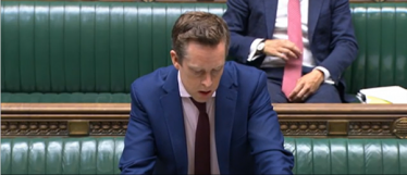 Tom stood in the House of Commons, answering a question. 