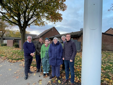 Tom Pursglove MP with a group of residents on Welland Vale Road in Corby, gathered next to the new 5G mast.
